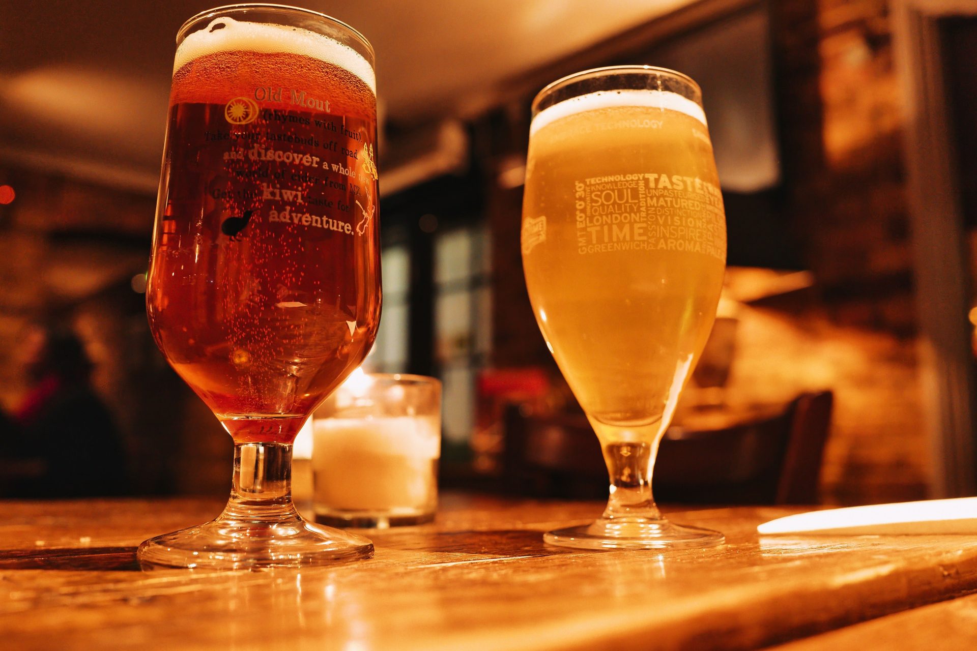 Warm and inviting pub setting with two beers on a wooden table.